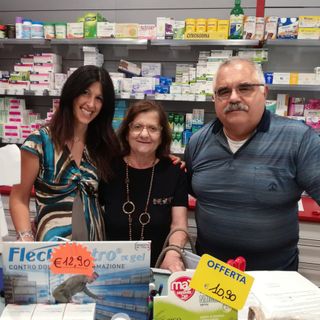 tre persone dietro il bancone di una farmacia