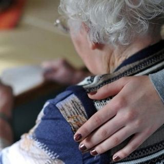 donna anziana con mano sulla spalla