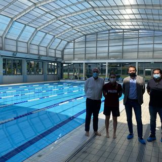 tre persone in una piscina al coperto a bordo vasca