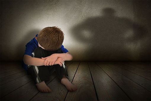 Bambino in difficoltà seduto a terra