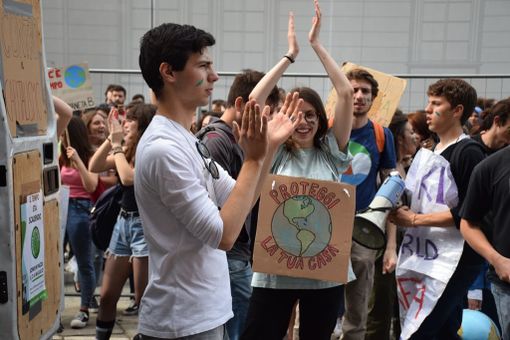 ragazzo davanti ad altri manifestanti con cartelli ragazzo davanti ad altri manifestanti con cartelli