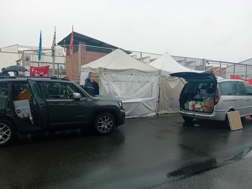 Persone insieme tra due auto con bagagliaio aperto Persone insieme tra due auto con bagagliaio aperto