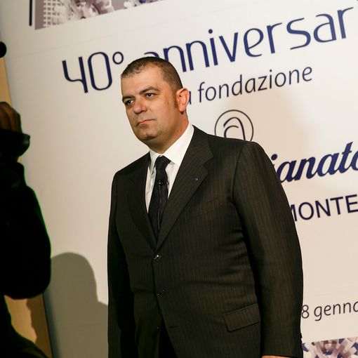 Uomo intervistato di fronte a pannello