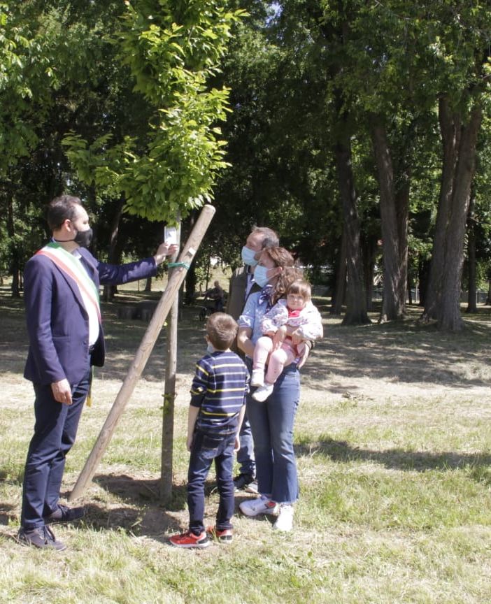 Sindaco con bambino e mamma vicino a un albero