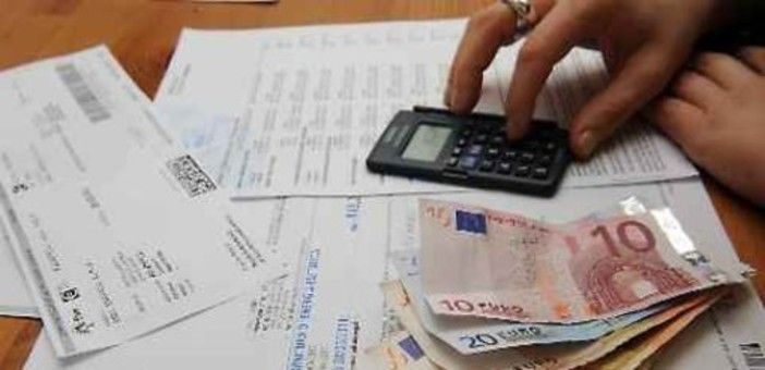 persona che fa calcoli con delle bollette sul tavolo