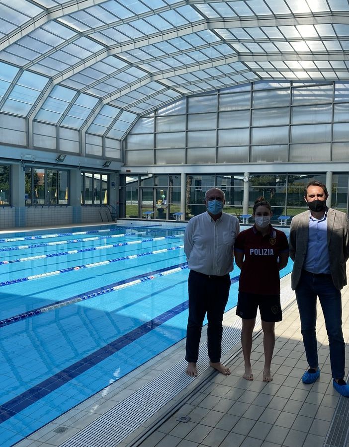 tre persone in una piscina al coperto a bordo vasca