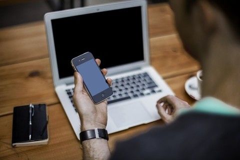 persona che consulta smartphone e pc