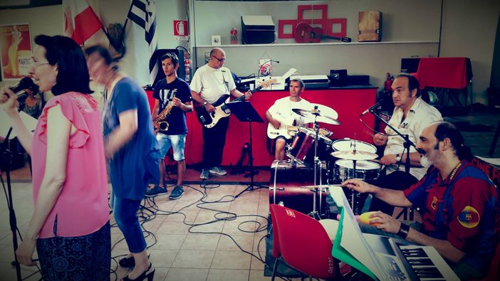 Persone che cantano e suonano in una stanza