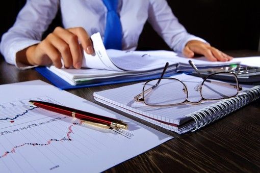 Persona con carte e bilanci davanti a sé