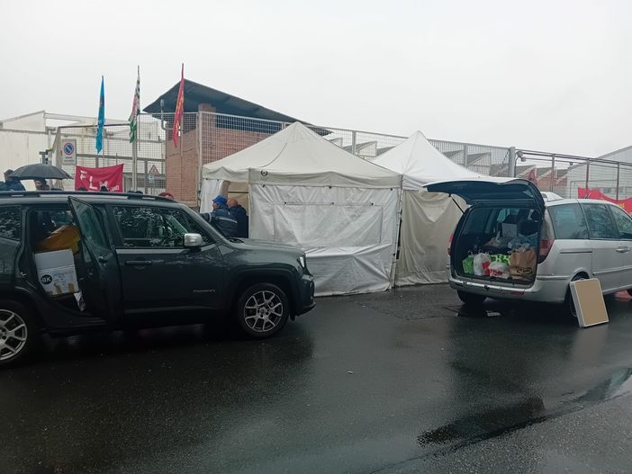 Persone insieme tra due auto con bagagliaio aperto