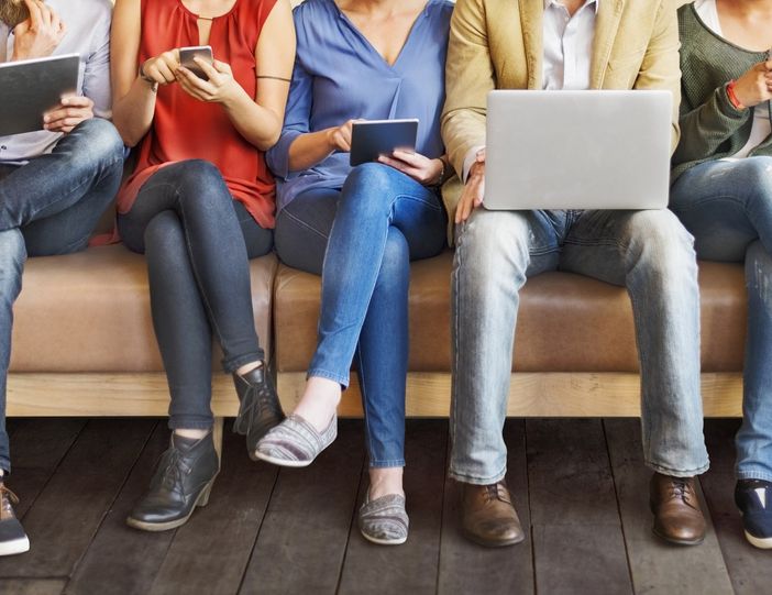 Persone sedute alle prese con dispositivi digitali