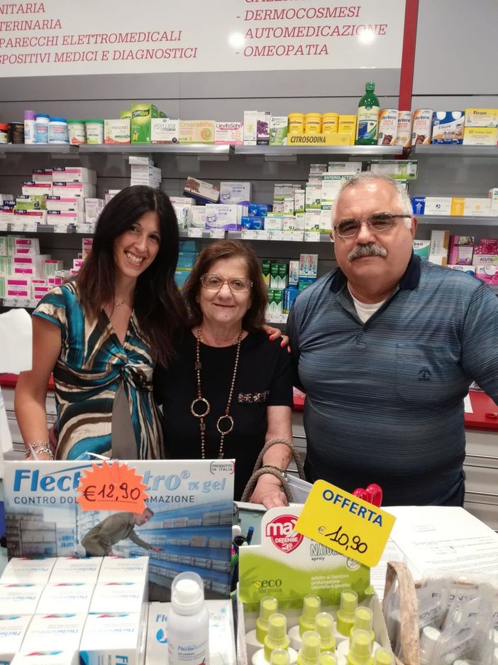 tre persone dietro il bancone di una farmacia