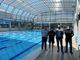 tre persone in una piscina al coperto a bordo vasca