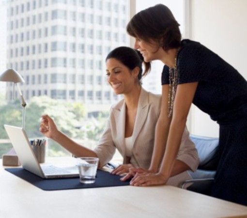 due donne alla scrivania mentre lavorano due donne alla scrivania mentre lavorano